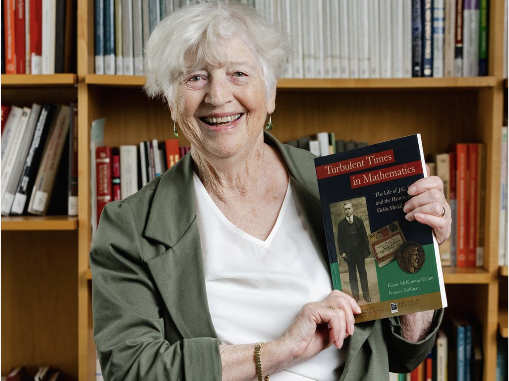 Elaine Riehm holds her biography of John Charles Fields in August 2024.